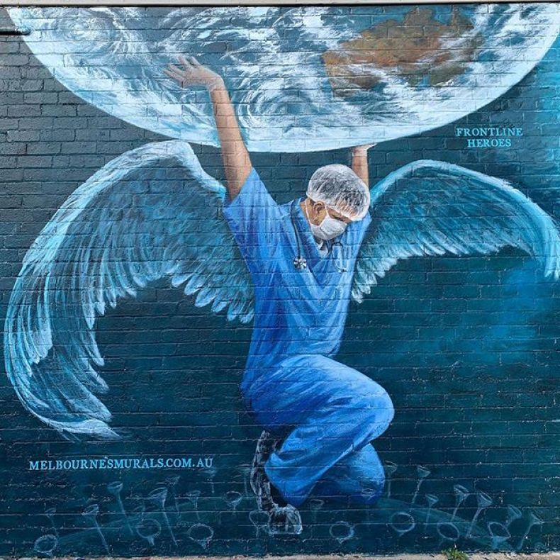 A nurse with wings holds the world on his shoulders. Coronavirus street art